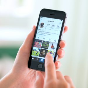 Kiev, Ukraine - May 30, 2014: Person holding a brand new Apple iPhone 5S with Instagram profile on the screen. Instagram is an online mobile social networking service, launched in October 2010.